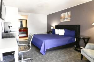 a hotel room with a bed and a table and a couch at R Nite Star Inn and Suites -Home of the Cowboys & Rangers in Arlington