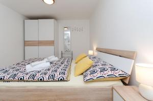 a bedroom with two beds and a mirror at House Marija in Mošćenička Draga