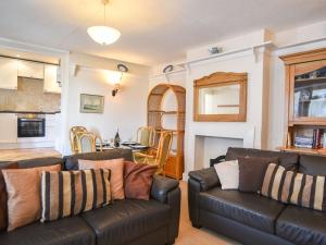 een woonkamer met 2 leren banken en een keuken bij Okanagan in Lyme Regis
