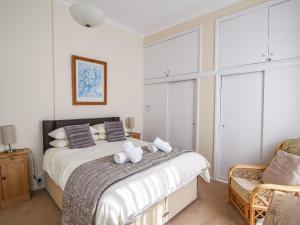 een slaapkamer met een bed met 2 kussens en een stoel bij Okanagan in Lyme Regis
