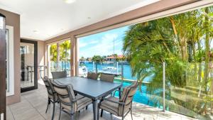 a dining room with a view of the water at Spacious Canal Home With Pool in Banksia Beach