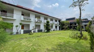 a building with a grass yard in front of it at LPP Convention Hotel Demangan in Yogyakarta