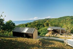 a house on a hill with a view of the ocean at Bobocabin Umarato, Sumba in Waikabubak