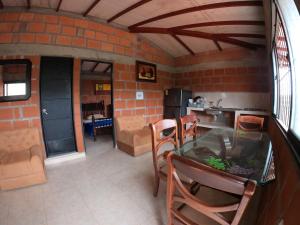 a living room with a glass table and a kitchen at VILLA ISABELLA in Curití +39 photos