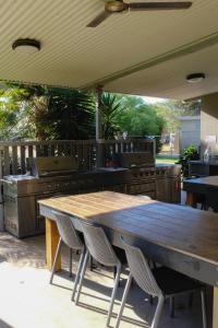 una cocina al aire libre con mesa de madera y sillas en Norwesta Lifestyle Park en Carnarvon