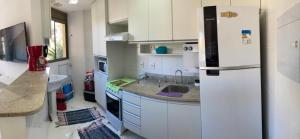 a kitchen with a refrigerator and a sink at apartamento na Reserva do Sahy em Mangaratiba RJ in Mangaratiba
