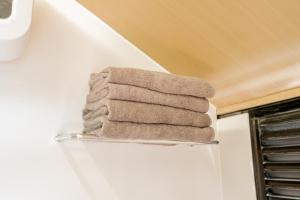 a stack of towels on a towel rack in a bathroom at Bobocabin Umarato, Sumba in Waikabubak