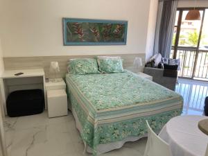 a bedroom with a bed and a desk and a window at apartamento na Reserva do Sahy em Mangaratiba RJ in Mangaratiba