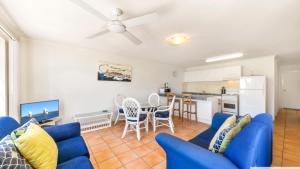 un soggiorno con divani blu e una cucina di Pacific Breakers Seaside Escape a Woorim