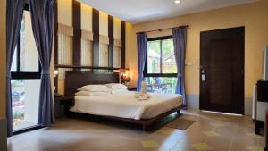 a bedroom with a bed with yellow and blue stripes at Pattaya Garden Resort in Pattaya North +39 photos