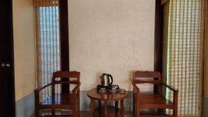 2 sillas y una mesa con un hervidor de agua. en Pattaya Garden Resort, en Norte de Pattaya