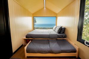 a small room with two beds and a window at Bobocabin Umarato, Sumba in Waikabubak