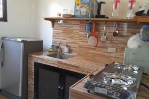 a small kitchen with a sink and a stove at Panawan Cinco in General Luna
