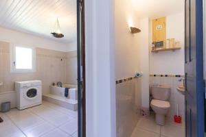 a bathroom with a toilet sink and a washing machine at JARDIN SECRET, Bas de villa TOUT CONFORT in Le Tampon +28 photos