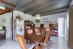 a kitchen with a wooden table and a refrigerator at JARDIN SECRET, Bas de villa TOUT CONFORT in Le Tampon