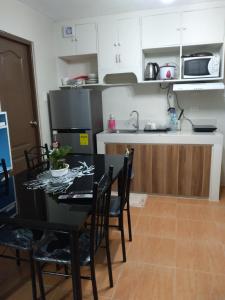 - une cuisine avec une table noire, des chaises et un évier dans l'établissement 2-BR One Oasis Condo in CDO, à Cagayán de Oro