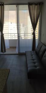 a living room with a couch and a large window at apartamento Lynch Costero Iquique in Iquique