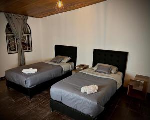 a bedroom with two beds and a table and a window at H&L BOUTIQUE in Bogotá