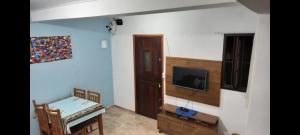 a living room with a tv on a wall at Casa simples e aconchegante em Boracéia Bertioga SP in Bertioga