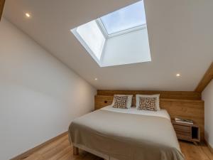 sypialnia z łóżkiem i świetlikiem w obiekcie Penthouse rénové à Courchevel avec parking et Wi-Fi - FR-1-563-130 w Courchevel