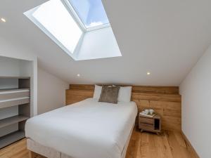 sypialnia z łóżkiem i świetlikiem w obiekcie Penthouse rénové à Courchevel avec parking et Wi-Fi - FR-1-563-130 w Courchevel