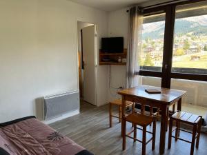 ein kleines Zimmer mit einem Tisch, einem Bett und einem Fenster in der Unterkunft Appartement Villard-de-Lans, 2 pièces, 4 personnes - FR-1-515-164 in Villard-de-Lans