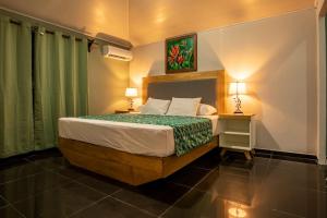 a bedroom with a bed with a green curtain at Anthurium house in Fortuna