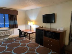 a hotel room with a desk and a television at Raceway inn in Martinsville