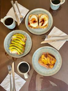 Cal Bed & Breakfast في بوغوتا: طاولة خشبية عليها ثلاثة اطباق من الطعام