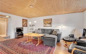 Gorgeous Home In Nrre Nebel With Wifi في Nymindegab: غرفة معيشة مع أريكة وطاولة
