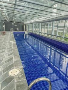 a large swimming pool with blue tiles in a building at Southbank Two Bedroom Apt - 2202 in Melbourne