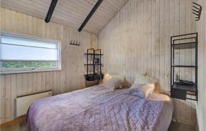 a bedroom with a bed in a wooden wall at Beach Front Home In Assens With House Sea View in Assens