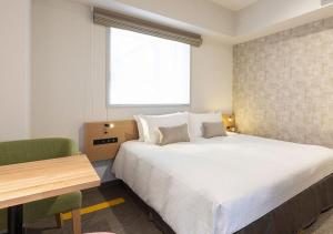 a bedroom with a bed and a desk and a window at Tokyu Stay Sapporo Odori in Sapporo