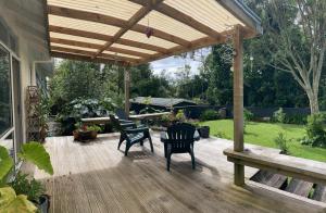 pérgola de madera con sillas y una mesa en una terraza en Okato Homestay, en Okato