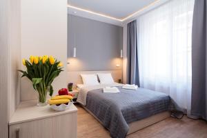 a bedroom with a bed and a vase of bananas at Apartamenty Platinia - komfortowe noclegi Kraków Stare Miasto in Krakow