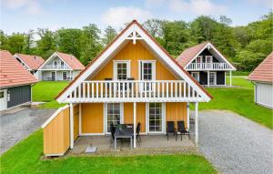 een klein geel huis met een wit dak bij Marina Fiskens Feriepark in Gråsten