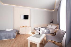 una camera con due letti e un tavolo con una sedia di Apartamenty Platinia - komfortowe noclegi Kraków Stare Miasto a Cracovia