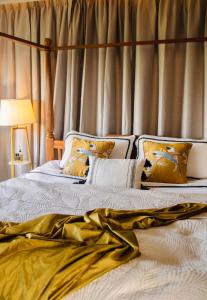 una camera da letto con letto con lenzuola e tende dorate di Sunset ocean view hilltop house a Salad Beach