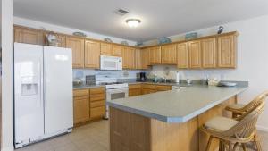 a kitchen with a white refrigerator and wooden cabinets at 509 E 15th Ave, Unit F in North Wildwood