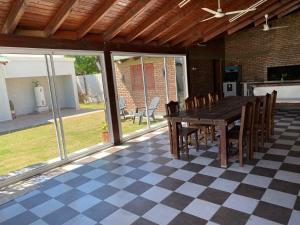 un patio con mesa y sillas en un suelo a cuadros en Hermosa Casa con Quincho y pileta en La Banda