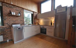 eine Küche mit Küchengeräten aus Edelstahl und einer Ziegelwand in der Unterkunft Awesome Home In Struer With Kitchen in Struer