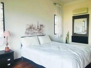 塞貝維的住宿－Romantic Suite by the Lake，卧室配有白色的床和墙上的绘画作品