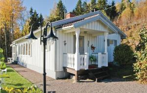 Nice Home In Kil With House Sea View في Säbytorp: مبنى أبيض صغير مع شرفة وضوء الشارع