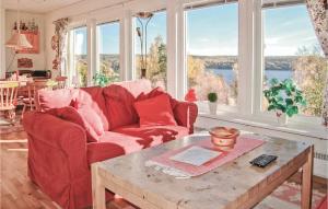 a living room with a red couch and a table at Nice Home In Kil With House Sea View in Säbytorp