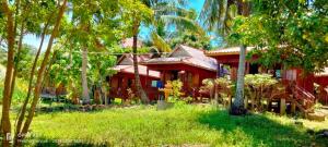 ein rotes Haus inmitten einiger Bäume in der Unterkunft Sok Mean Bungalows in Koh Rong Sanloem