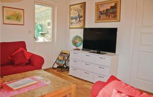 a living room with a tv and a red couch at Nice Home In Kil With House Sea View in Säbytorp
