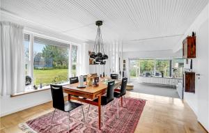 comedor con mesa de madera y sillas negras en 5 Bedroom Amazing Home In Bandholm, en Bandholm