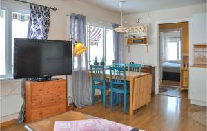 een woonkamer met een televisie en een tafel met stoelen bij 2 Bedroom Amazing Home In Rottneros in Rottneros