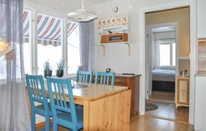 2 Bedroom Amazing Home In Rottneros في Rottneros: مطبخ مع طاولة خشبية وكراسي زرقاء