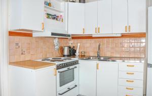a kitchen with white cabinets and a stove top oven at 2 Bedroom Amazing Home In Rottneros in Rottneros